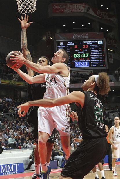 El escolta del Madrid Jaycee Carroll entra a canasta ante la oposición de David Moss y Shaun Stonerook.