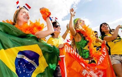 Torcedoras brasileiras e holandesas trocam suas bandeiras antes do jogo.