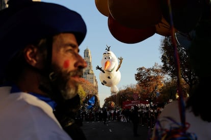 Imagen de participantes del desfile con el globo gigante del personaje de Frozen, Olaf, al fondo. 