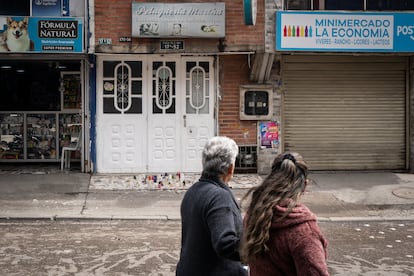Dos mujeres miran hacia la peluquería donde fue asesinada Yesica Chávez en el barrio Quintas del Sur, en la localidad de Ciudad Bolívar, en Bogotá, el 24 de abril de 2025.