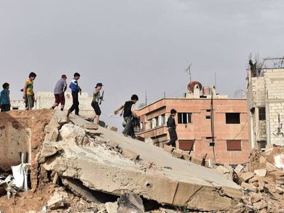 Un grupo de ni&ntilde;os juega sobre las ruinas de un edificio al sur de Damasco.