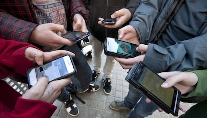 Varios adolescentes estudiantes de un instituto barceon&eacute;s conectados a las redes sociales a traves de sus telefonos m&oacute;viles, en Barcelona