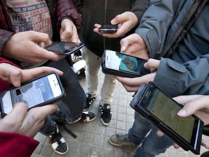 Varios adolescentes estudiantes de un instituto barceon&eacute;s conectados a las redes sociales a traves de sus telefonos m&oacute;viles, en Barcelona