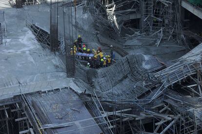 Derrumbe de un edificio en construcción en Manila. En la imagen, los equipos de rescate recuperan el cuerpo de uno de los trabajadores que murieron en el accidente.