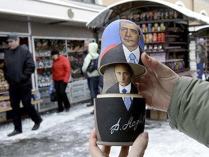 Un vendedor muestra una tradicional <i>matrioshka</i> rusa con los retratos de Dmitri Medvédev y Vladímir Putin en San Petersburgo.
