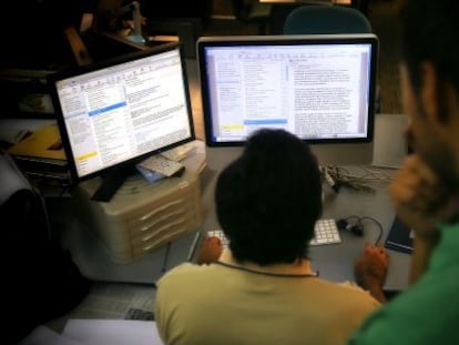 Un trabajador lee el correo electr&oacute;nico en un ordenador de la oficina.