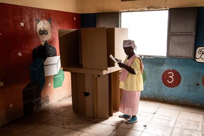 Una mujer dobla su papeleta de voto en una cabina de votación en Luanda, este miércoles.