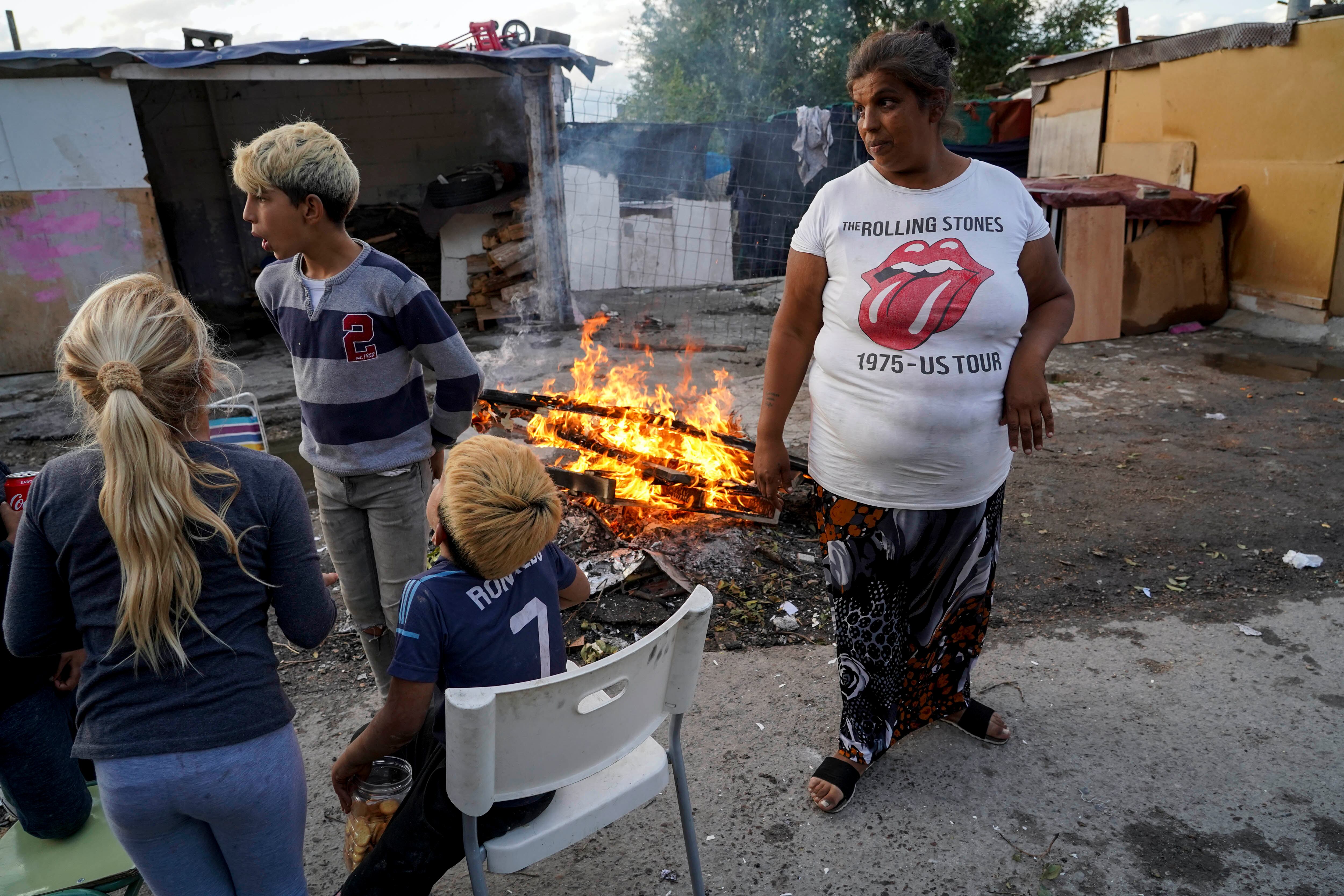 Una familia junto a una fogata delante de su chabola en la parte baja del poblado de la Cañada Real