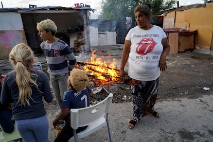 Una familia junto a una fogata delante de su chabola en la parte baja del poblado de la Cañada Real