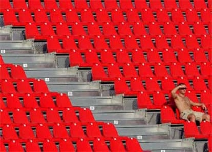 Un espectador asiste en solitario en una zona de la grada al partido de hockey sobre hierba entre Alemania y Australia.