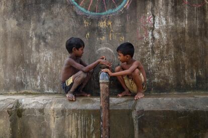 Niños rohingyas se sientan junto a una tubería de agua en el campo de refugiados de Cox's Bazar (Bangladés).
