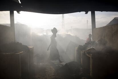Una mujer camina en el humo de un incendio en un mercado en Puerto Príncipe, Haití.