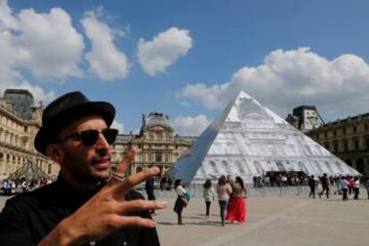 El artista franc&eacute;s JR posa hoy con su fotograf&iacute;a en la pir&aacute;mide del Louvre.