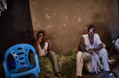 Un hombre y su hijo, ambos de Burundi, dentro de su casa en el campo de refugiados de Dzaleka.