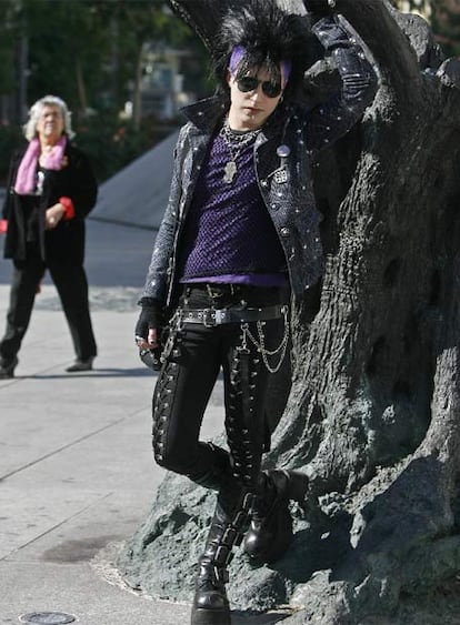 Un joven  gtico, junto a una escultura de la plaza de Felipe II.