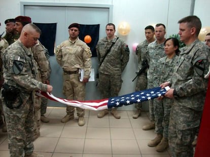 Soldados de EEUU doblan la bandera antes de abandonar su base.