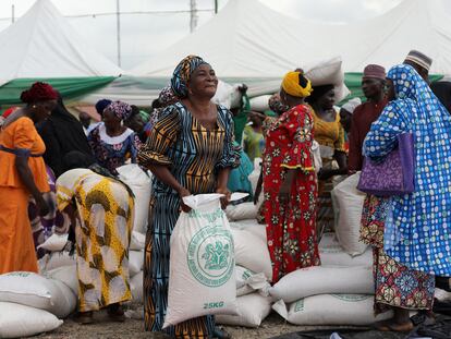 Varias mujeres recogen sacos de alimentos en una distribución en Abuja, organizada por el Gobierno de Nigeria para amortiguar el alto coste de vida.