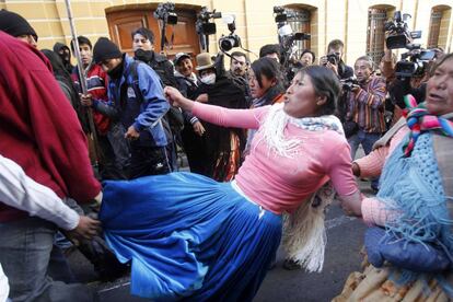 Una partidaria del presidente Evo Morales golpea a un policía durante la protesta.