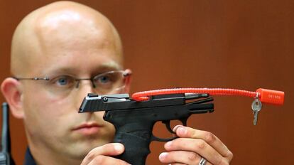 Un polic&iacute;a sujeta la pistorla con la que Zimmerman mat&oacute; al joven Trayvor Martin en 2013.