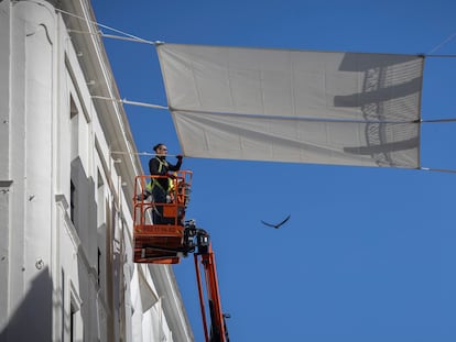 Operarios trabajan en la colocación de toldos para aliviar el calor en el centro de Sevilla.