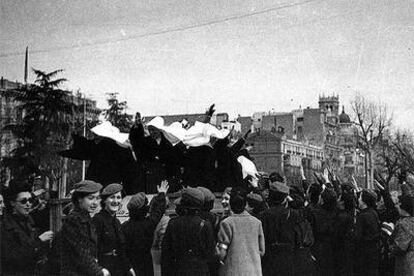 Un grupo de monjas saluda brazo en alto desde un camión a la gente congregada en Madrid, recién terminada la Guerra Civil.