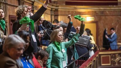 Varias personas celebran desde la tribuna de invitados de la Asamblea francesa la modificación constitucional sobre el aborto.