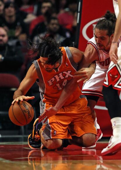 Luis Scola, de los Phoenix Suns, controla el balón de rodillas ante Joakim Noah