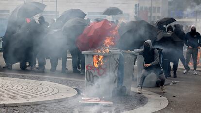 Unos jóvenes empujan cubos en llamas durante la protesta en Nantes (oeste de Francia), este martes.