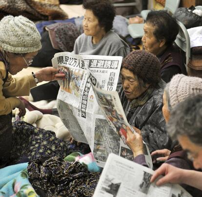 Un grupo de ancianos lee la prensa en un refugio cercano a Fukushima, tras evacuados por el accidente nuclear.