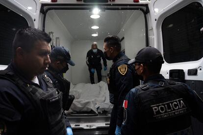 Elementos de la policía capitalina resguardan los cuerpos sin vida que fueron hallados después del tiroteo en la Colonia Roma de Ciudad de México.