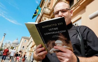 Un cura lee el libro entrevista del Papa emérito Benedicto XVI.