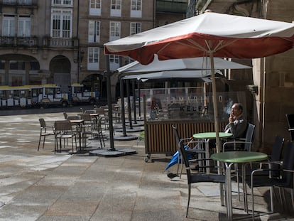 Un hombre fuma sentado en una terraza en la Plaza Mayor de Ourense.