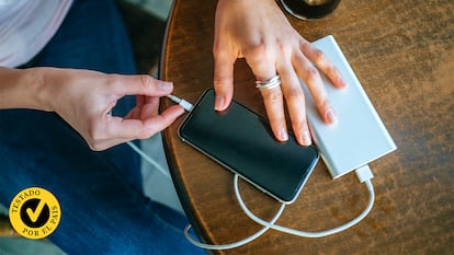 Una mujer conectando el móvil a una powerbank.