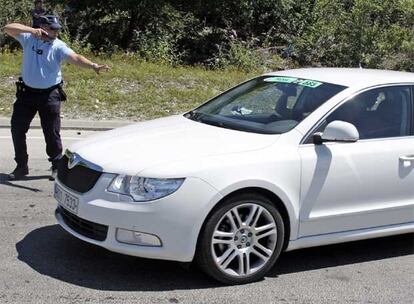 Un gendarme esgrime una  pistola ante el coche de Schleck.