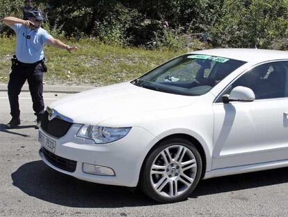 Un gendarme esgrime una  pistola ante el coche de Schleck.