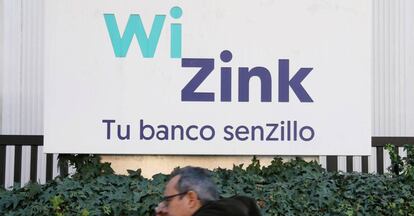 Un hombre pasea delante de un cartel de WinZink