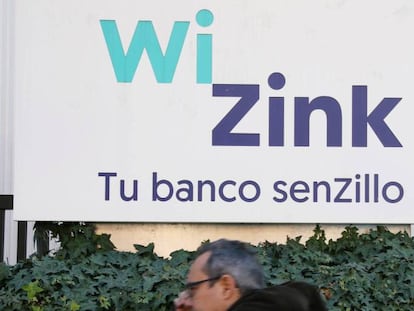 Un hombre pasea delante de un cartel de WinZink