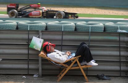 Un empleado del circuito de Shanghái descansa al paso de Raikkonen.