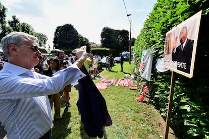 Un hombre hace una foto del retrato de Silvio Berlusconi, junto a la casa del ex primer ministro italiano.