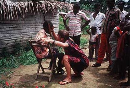 Una cooperante atiende a un niño dentro de un programa de ayuda en África.