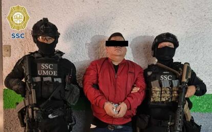 Dos elementos de la Secretaría de Seguridad Ciudadana resguardan a 'La vaca' tras su detención en Ciudad de México, el 18 de agosto.
