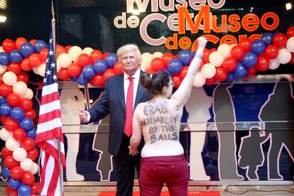 Una activista feminista irrumpe durante la presentación de la figura de Donald Trump, en el Museo de Cera de Madrid.