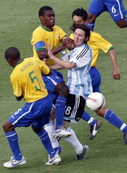 El central brasileño Juan comete falta a Messi, defendido también por Mineiro y Josué.