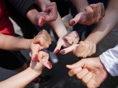 Personas muestran sus pulgares marcados con tinta, luego de votar este domingo.