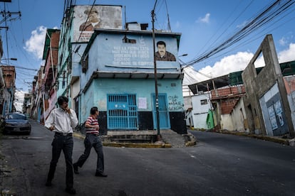 Peatones caminan frente a un mural de Nicolás Maduro en el barrio de Petare, en Caracas, en 2019.