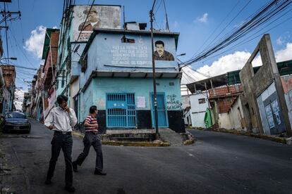 Peatones caminan frente a un mural de Nicolás Maduro en el barrio de Petare, en Caracas, en 2019.