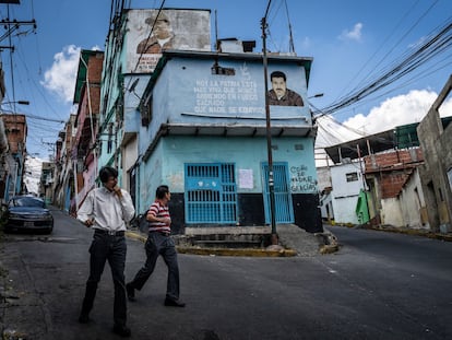 Peatones caminan frente a un mural de Nicolás Maduro en el barrio de Petare, en Caracas, en 2019.