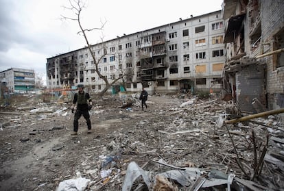 Voluntarios británicos buscan a residentes para proceder a su evacuación en el patio de un edificio de apartamentos destrozado en Bajmut.