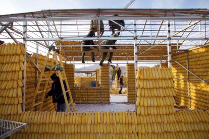 Un grupo de personas construye una casa con mazorcas de maiz en Jilin (China).