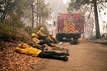 Un grupo de bomberos descansa después de luchar contra fuego cerca de North Fork (California).